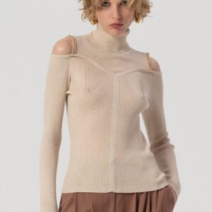 Model draagt de Francomina knit top chain detail in beige met open schouders en gouden ketting.